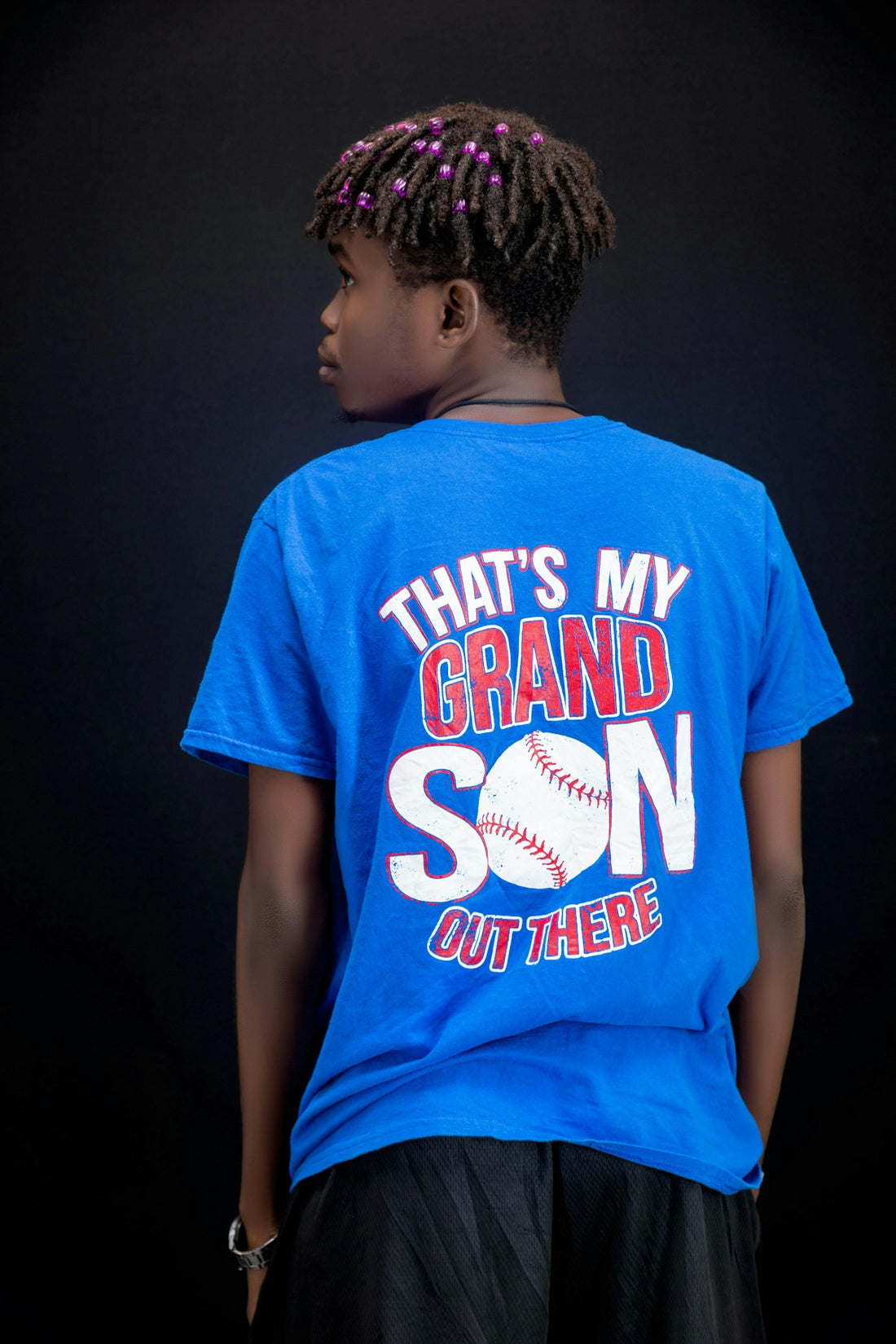 Young person wearing a blue t-shirt with baseball graphic.