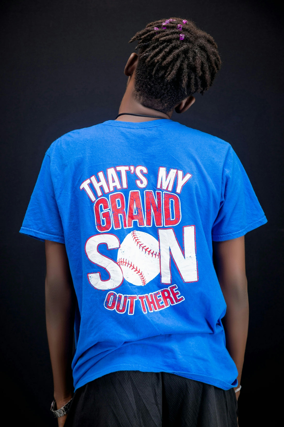 Person wearing a blue t-shirt with baseball graphic.