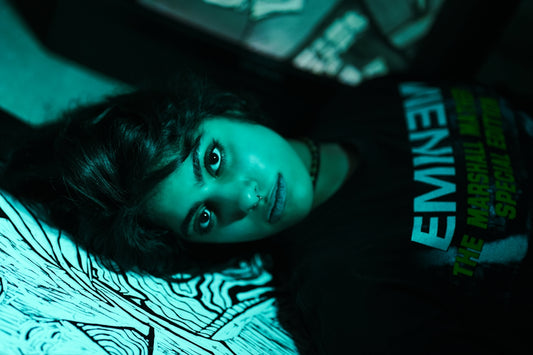 Young woman in eminem shirt lies on bed
