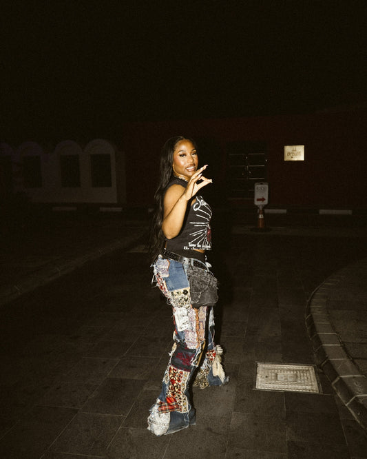 Woman in patchwork pants poses outdoors at night