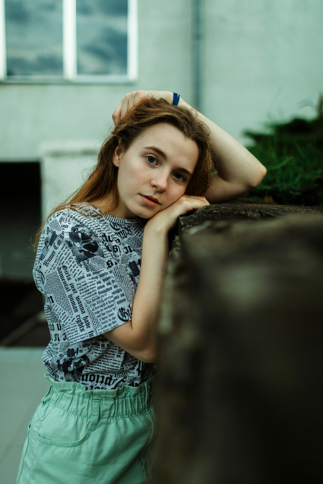 Young woman resting her head on a wall