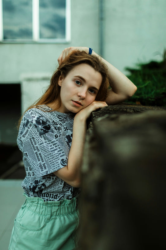Young woman resting her head on a wall