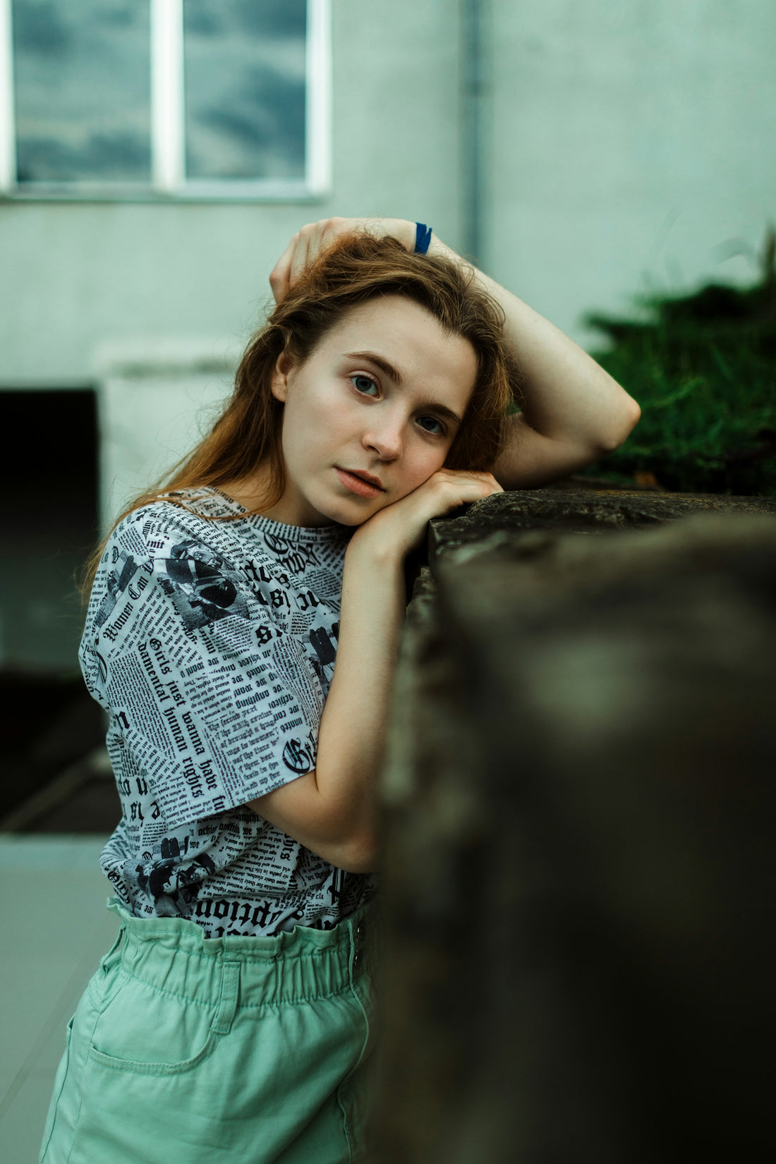 Young woman resting her head on a wall