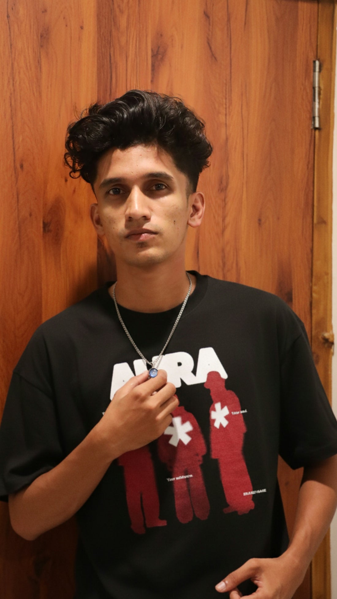 Young man in black t-shirt with graphic design.