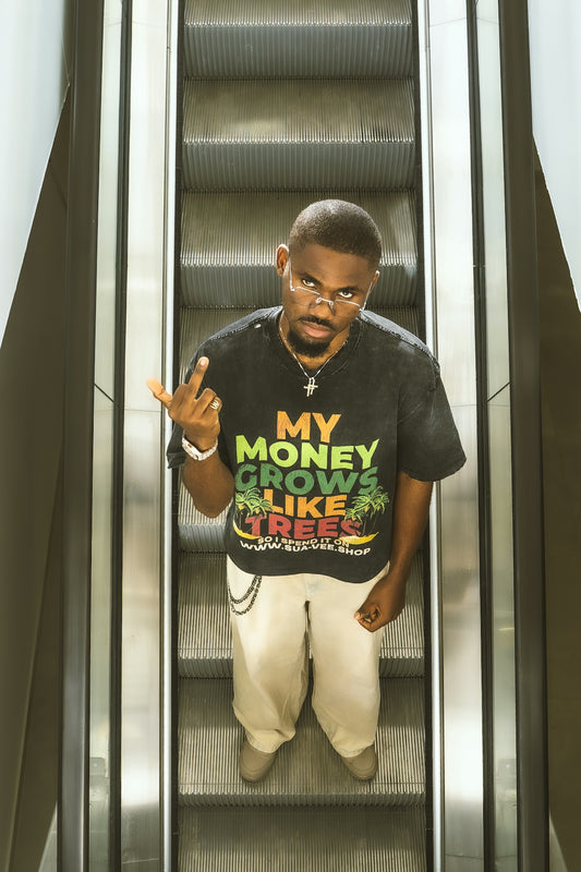 Man on escalator wearing a graphic t-shirt and pants.