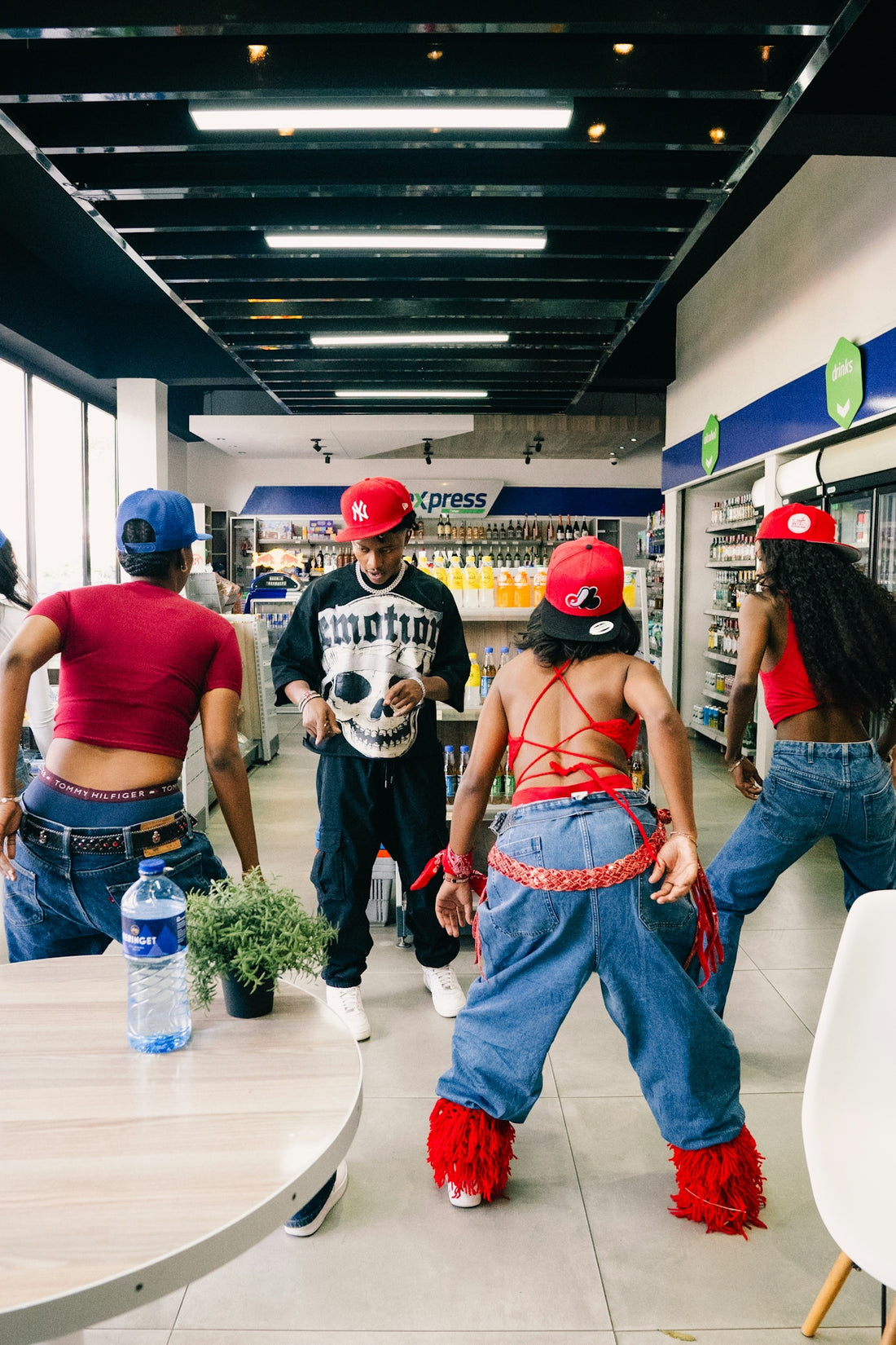 Four people dancing in a convenience store