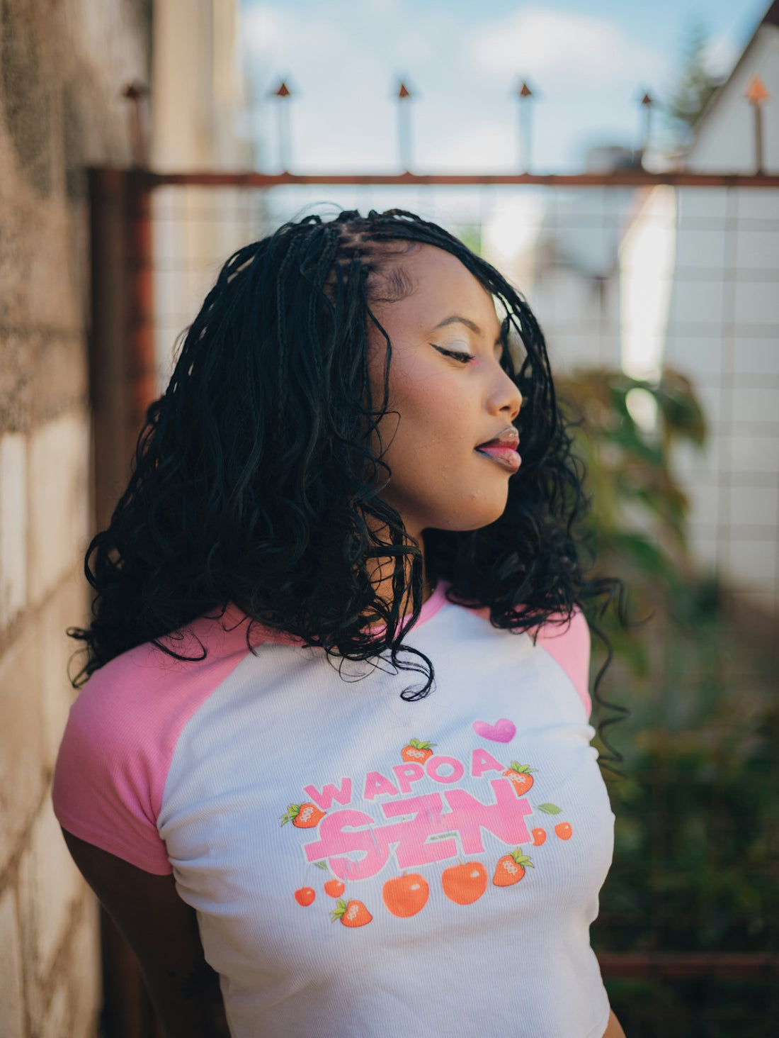 Woman with braided hair wearing a pink and white shirt