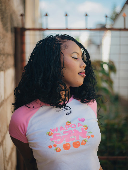 Woman with braided hair wearing a pink and white shirt