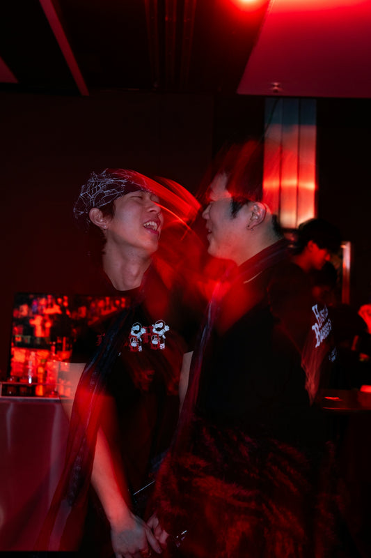 Two men laughing in red light