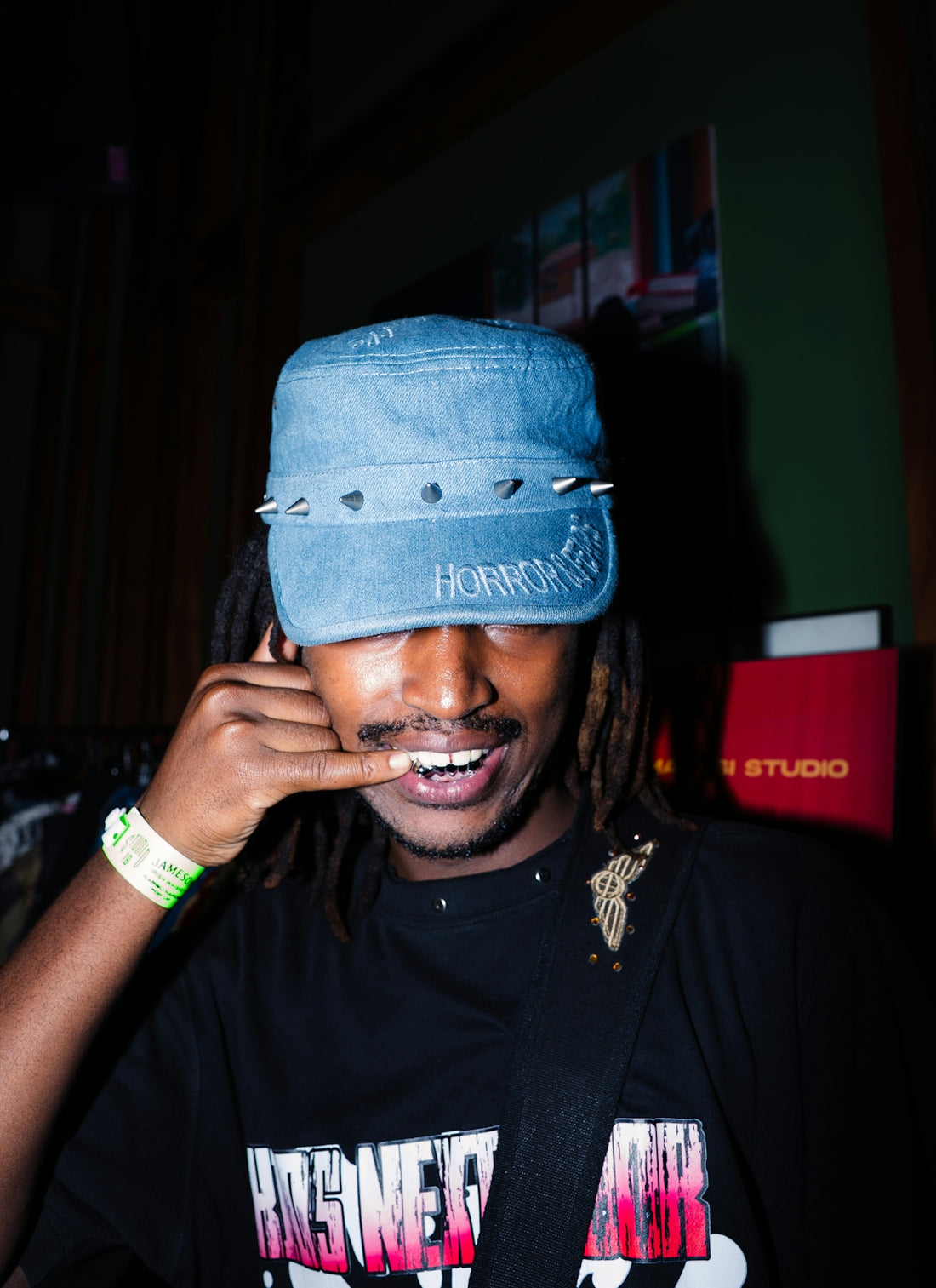 Man in denim hat makes a call gesture