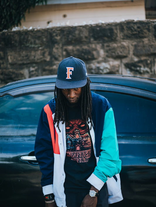 Man wearing a colorful jacket and baseball cap.