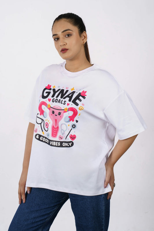 Woman wearing a white t-shirt with gynae goals graphic.