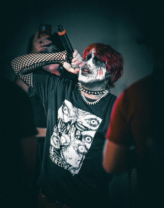 Person with face paint and red hair singing
