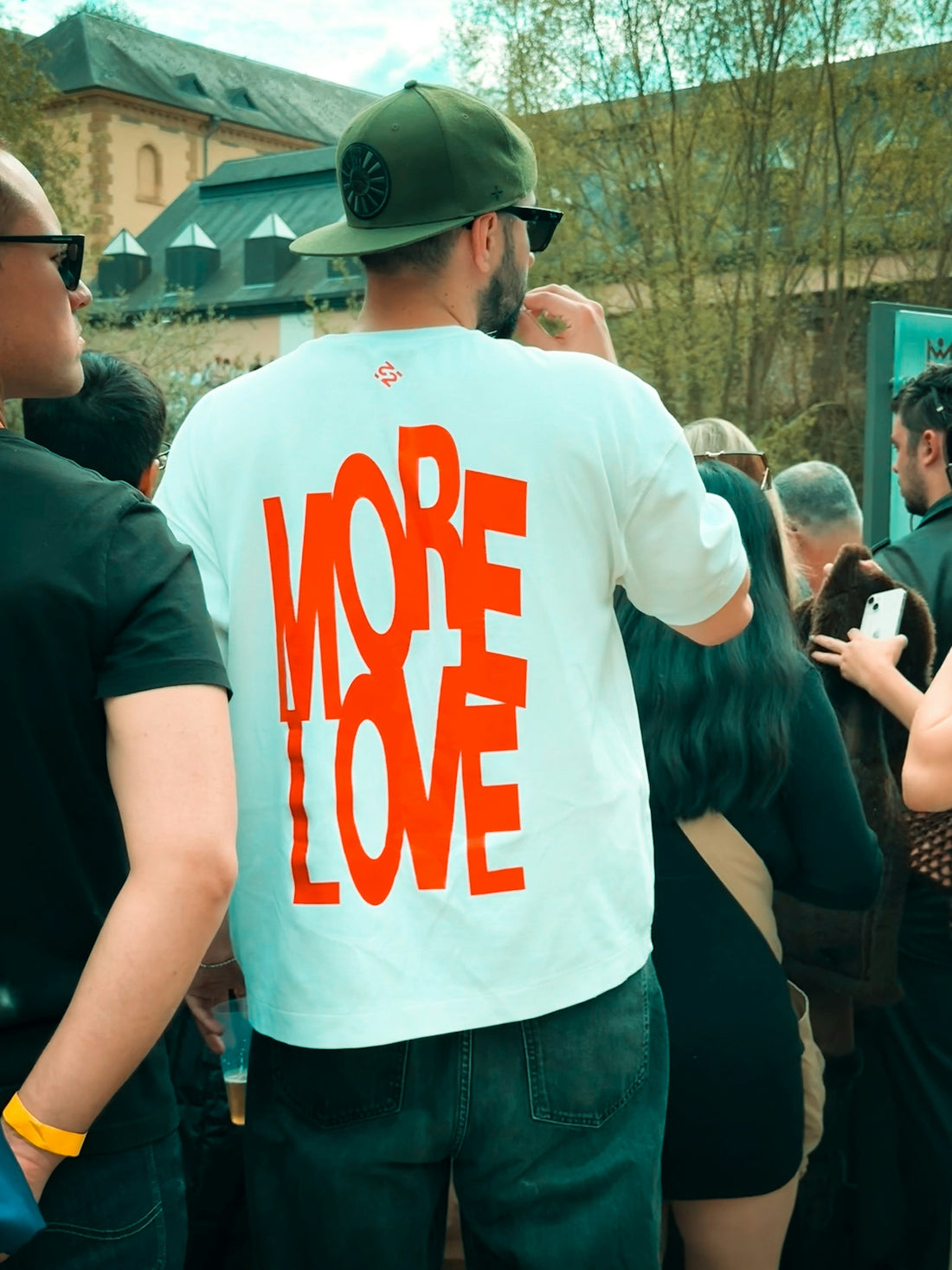 Man wearing white t-shirt with orange more love text.