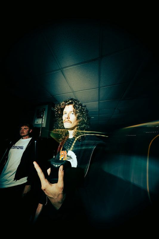 Curly-haired man with mustache making rock gesture