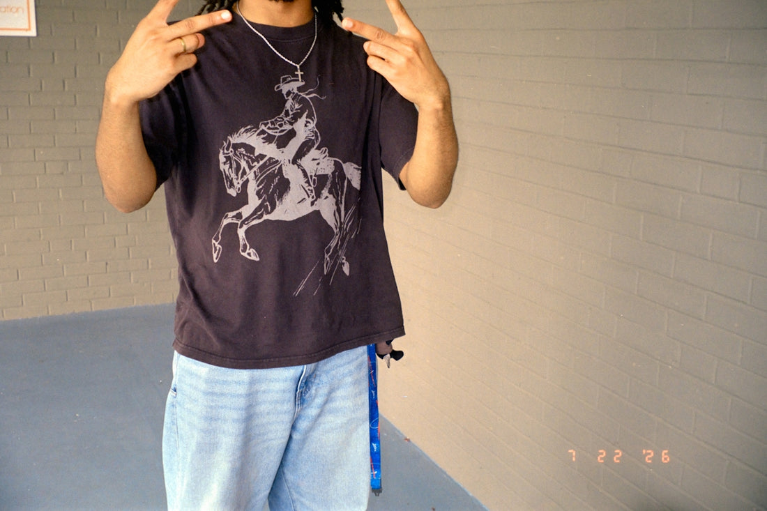 Person wearing t-shirt with horse graphic making peace signs