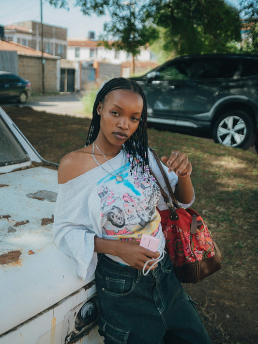 Young black woman leaning on a rusty car outdoors