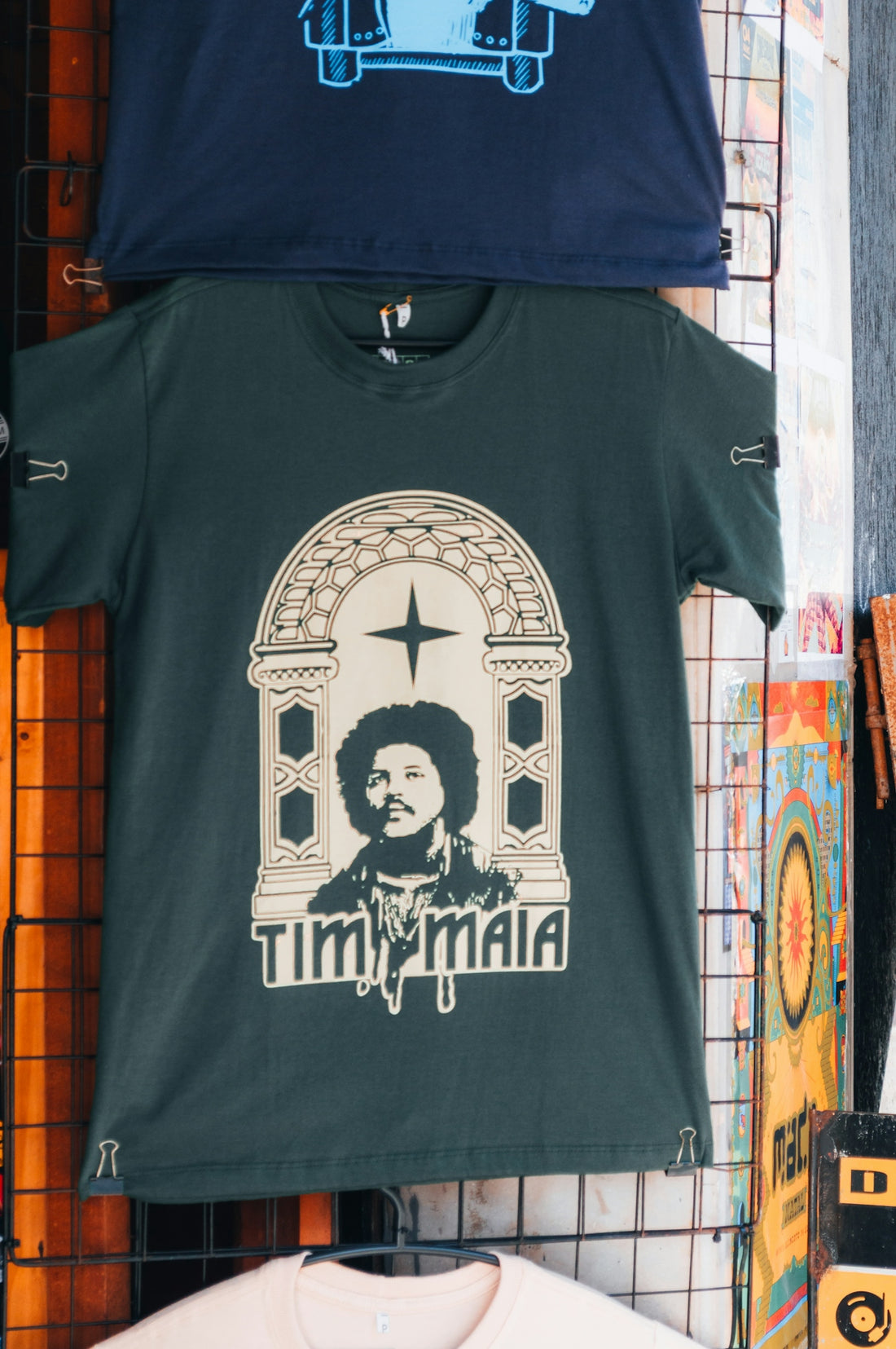A dark green t-shirt with a graphic of Tim Maia in an archway